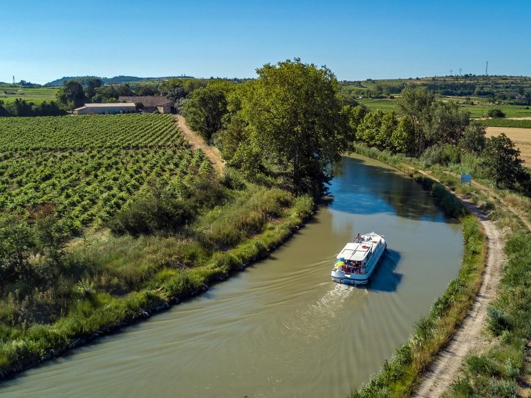 Navigation fluviale sur le canal du Midi, dans l'Aude, à travers vignes ©Jay Si, Istock